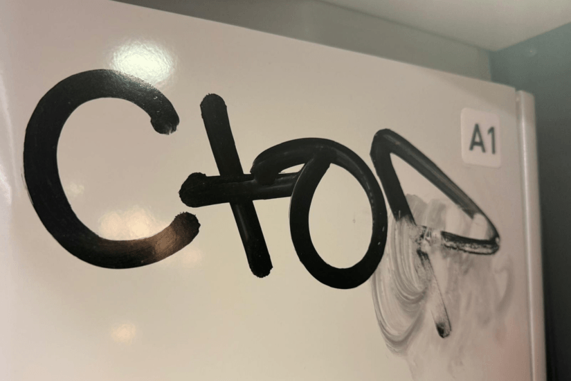 Graffiti tags on a painted door before professional removal