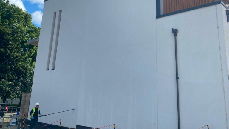 QCS operative carrying out softwash cleaning on a college wall in Coatbridge